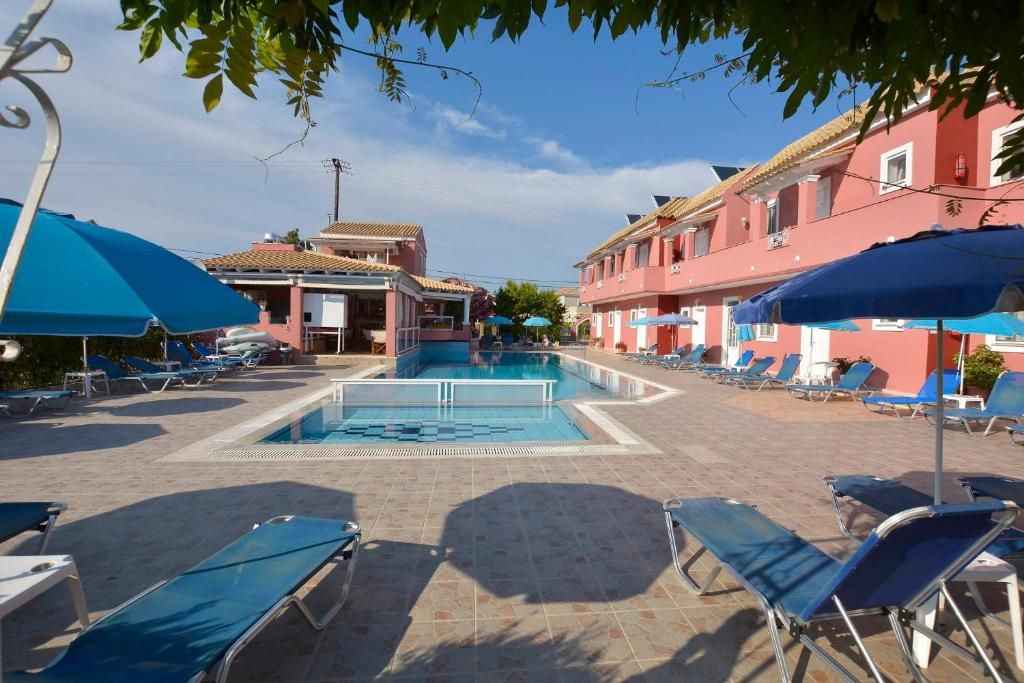 Sun loungers and parasols around the pool, with the apartments of the property behind